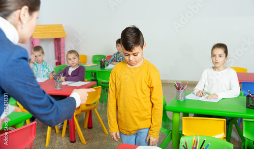 Slika na platnu Female teacher scolding guilty student in elementary school class