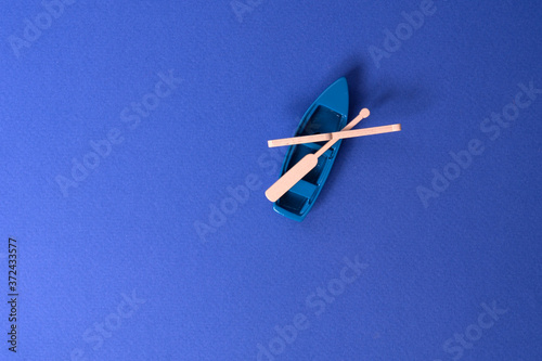 small wooden boat model on blue background