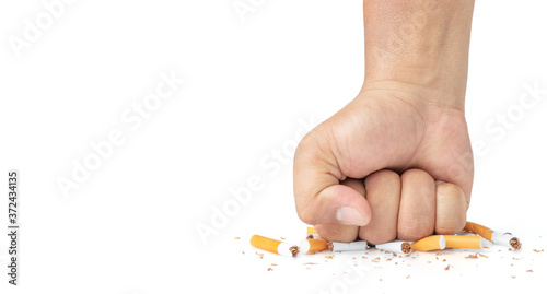 Man hand smash cigarette on white background, Man's fist crushing cigarettes, Stop smoking initiative concept of breaking cigarettes, World no tobacco day..
