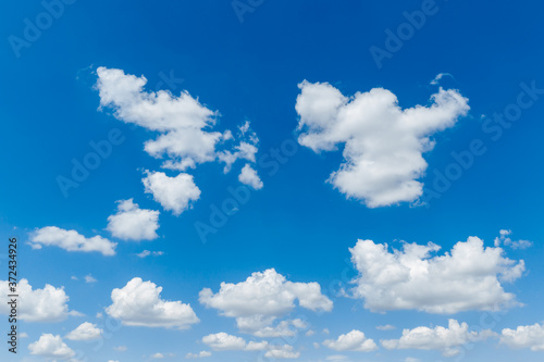 Blue clear sky with white fluffy clouds. Natural background