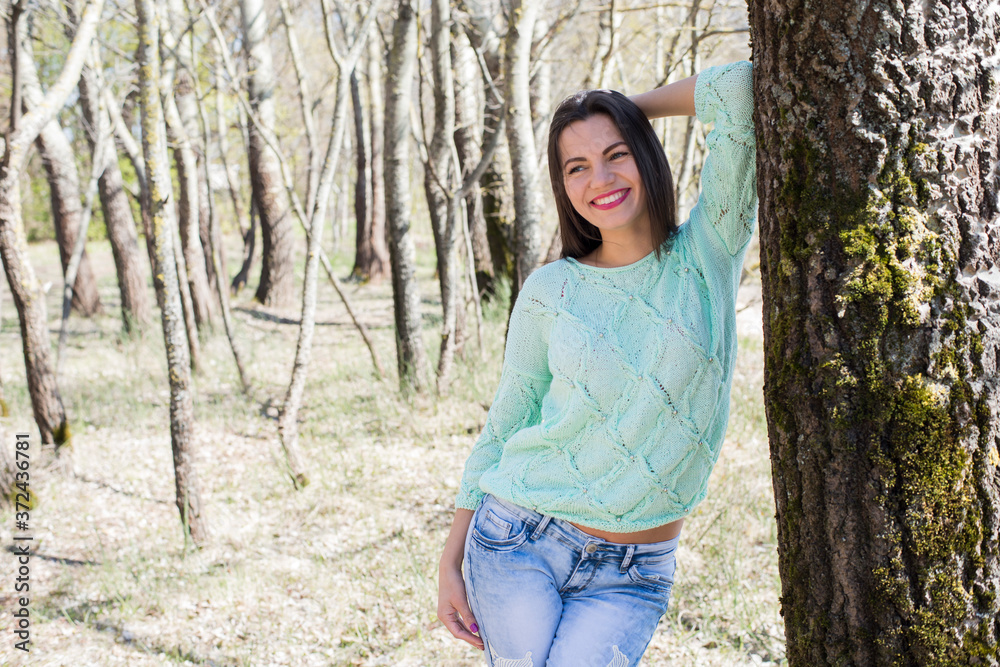 Woman in a knitted pullover walking in the park and posing
Woman in a knitted pullover walking in the park and posing