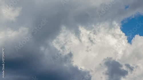 White cumulus clouds on a blue sky. Time Lapse.