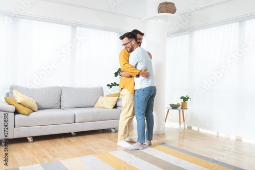 Gay couple embracing at home