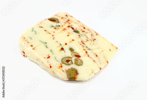 Slice of Pecoricco, a Sicilian sheep-goat cheese
stuffed with rocket, capers, olives and red chilli on white background
