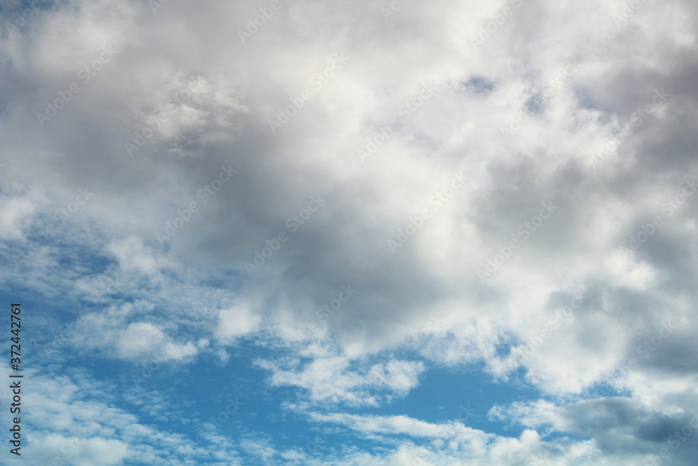Blue bright sky with clouds, natural beautiful background. Soft daylight. Stock photo with empty space for text and design. Blue bright sky with clouds, natural beautiful background. Soft daylight. Stock photo with empty space for text and design.