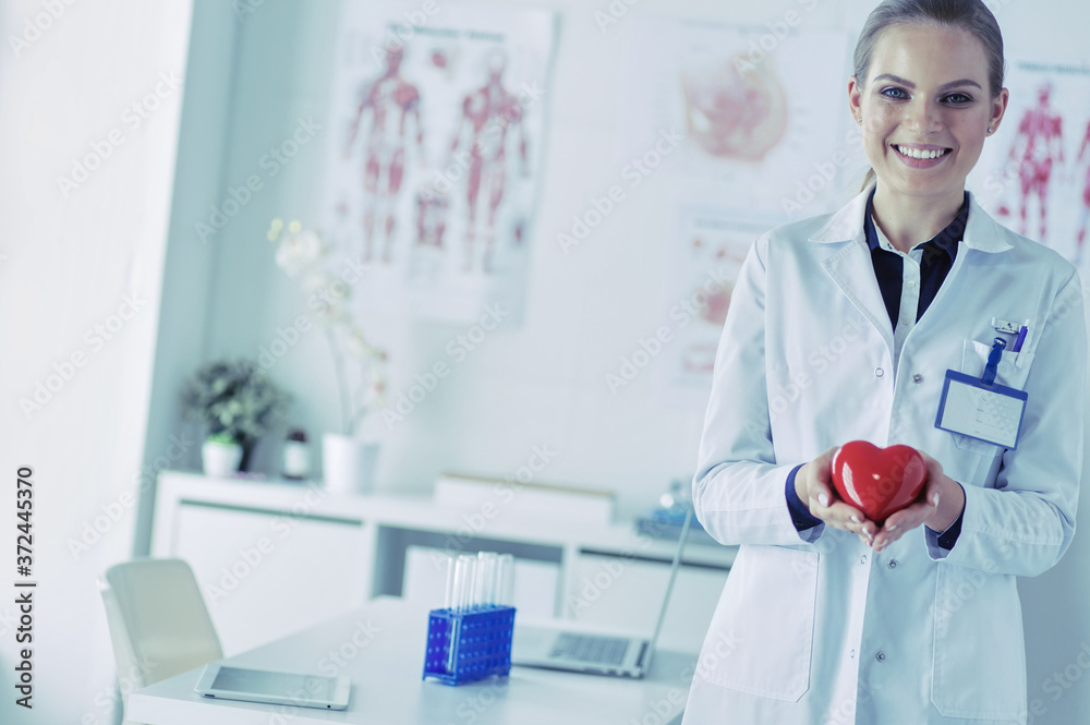A doctor with stethoscope examining red heart, isolated on white background A doctor with stethoscope examining red heart, isolated on white background