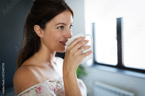 Fototapeta Naklejka Na Ścianę i Meble -  Beautiful woman enjoys her cup of tea or coffee
