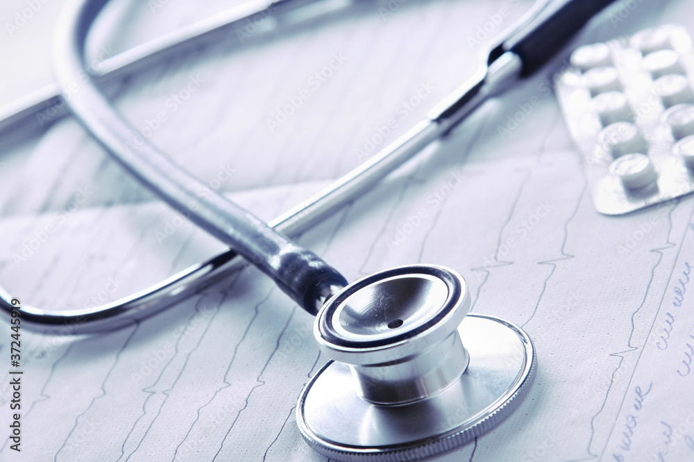 Medical stethoscope on electrocardiogram on desk Medical stethoscope on electrocardiogram on desk
