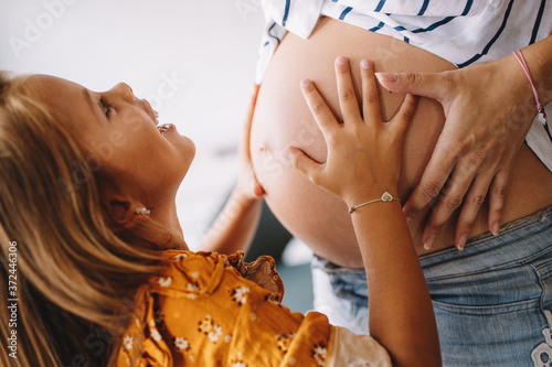 Fototapeta Beautiful pregnant woman with cute daughter