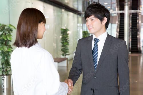 握手をするビジネスマンと女性医師