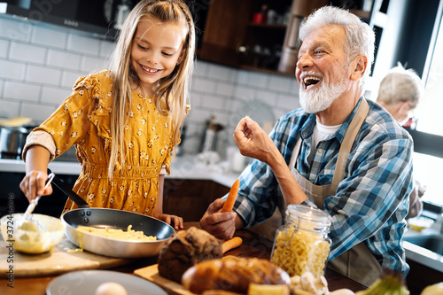 Happy senior couple having breakfast with their grandchildren at home