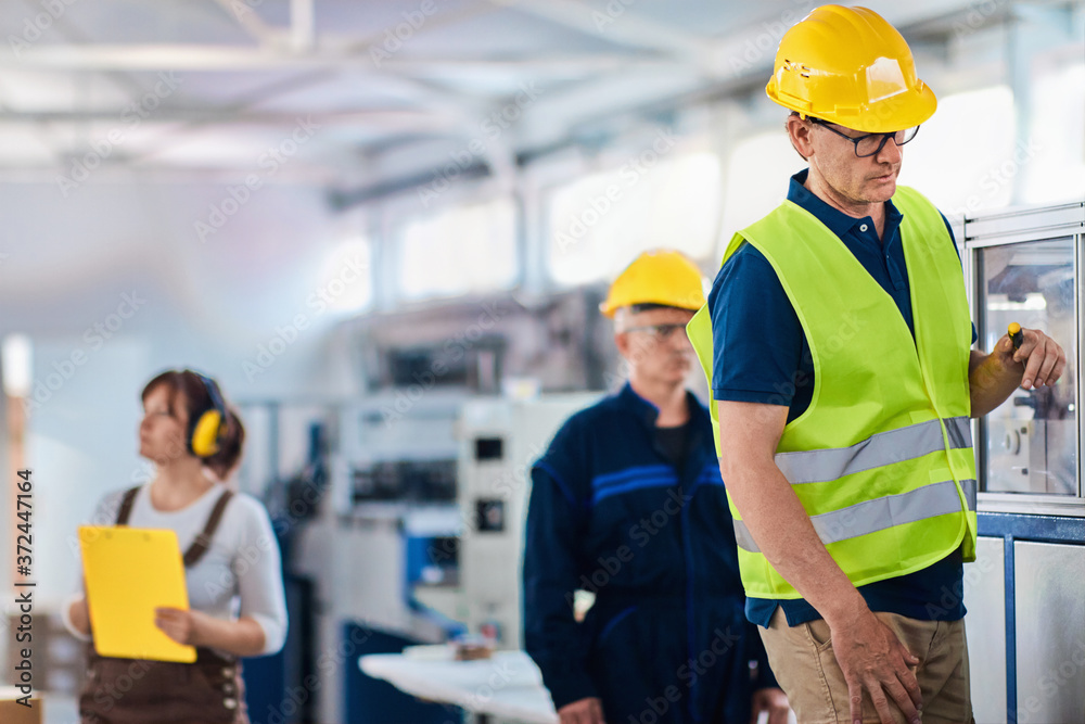an and woman workers in a factory, working as a team an and woman workers in a factory, working as a team