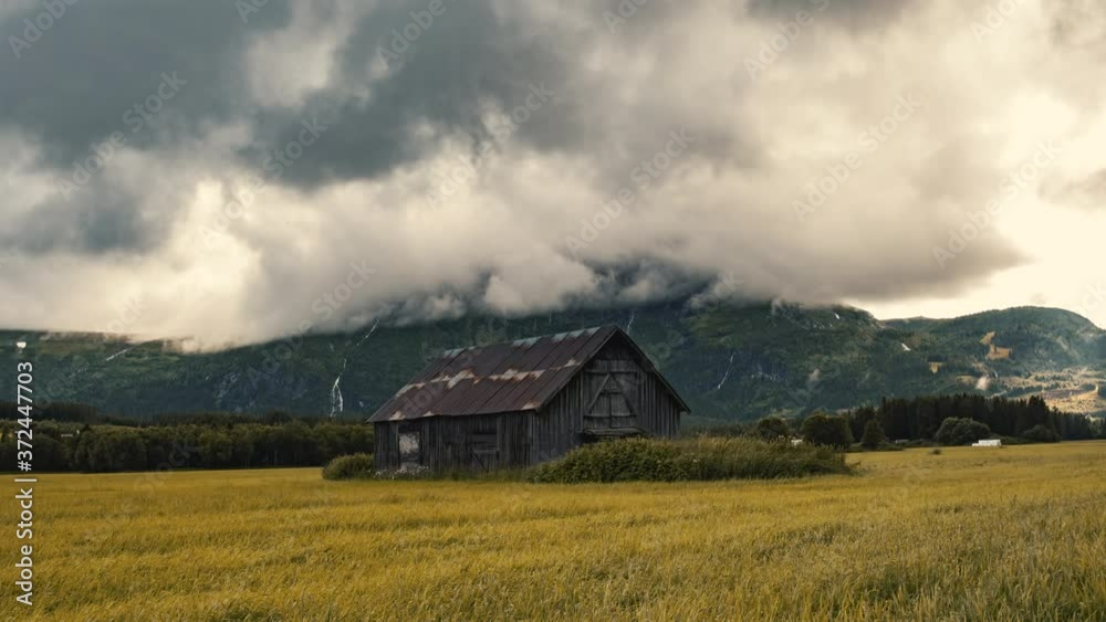 Abandoned Barn House Settled On Autumnal Lush Field With Thick Rolling Clouds Above- Wide Shot Abandoned Barn House Settled On Autumnal Lush Field With Thick Rolling Clouds Above- Wide Shot
