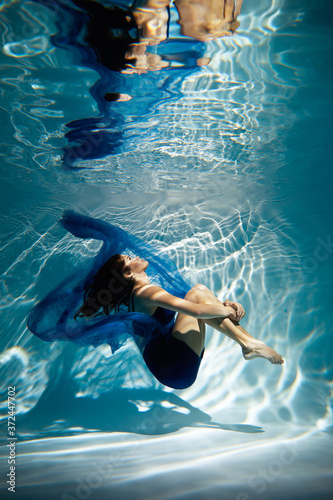  Woman in blue dress under water.