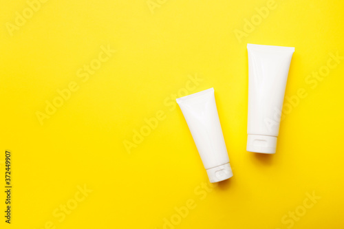 Wallpaper Mural Cream bottles on bright yellow background, top view, copy space. Cosmetics product and skin care concept. Mock up Torontodigital.ca