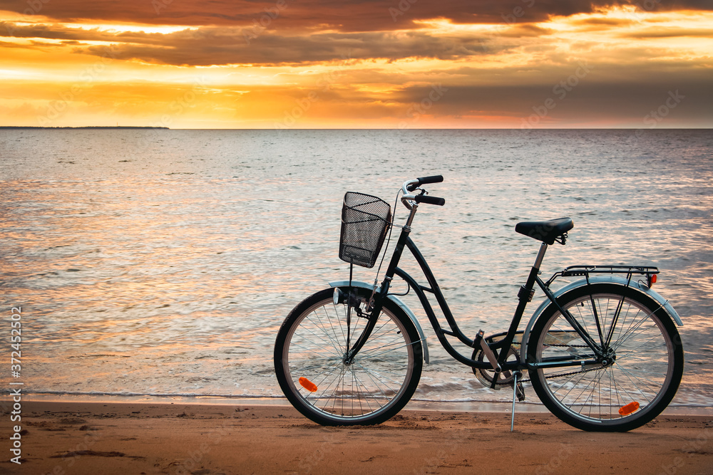 Fototapeta premium Lonely bike standing at sunset at seaside