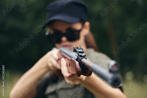 Woman on nature gun sight hunting black cap green 