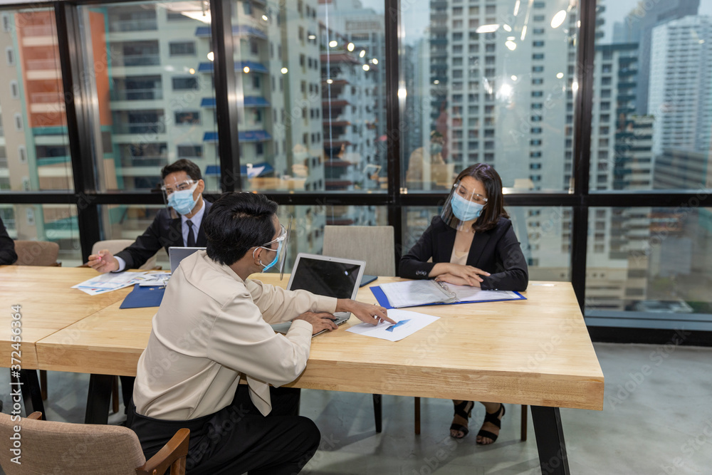 Business in new normal. Office workers wearing face mask and protection while having internal meeting for new business strategy or plan. Technology for new normal Business in new normal. Office workers wearing face mask and protection while having internal meeting for new business strategy or plan. Technology for new normal