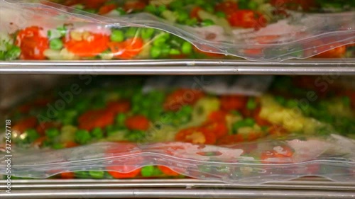 Detail of some plasticbags filled with vegetables in a refrigerated shelf (4k). photo