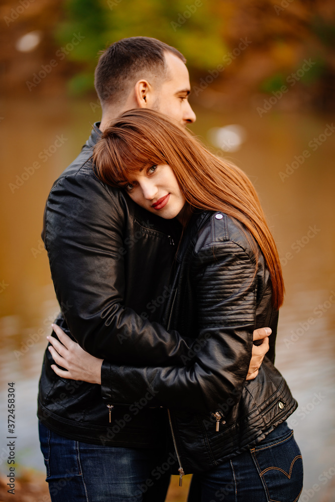 close up. couple hug in autumn park near river.