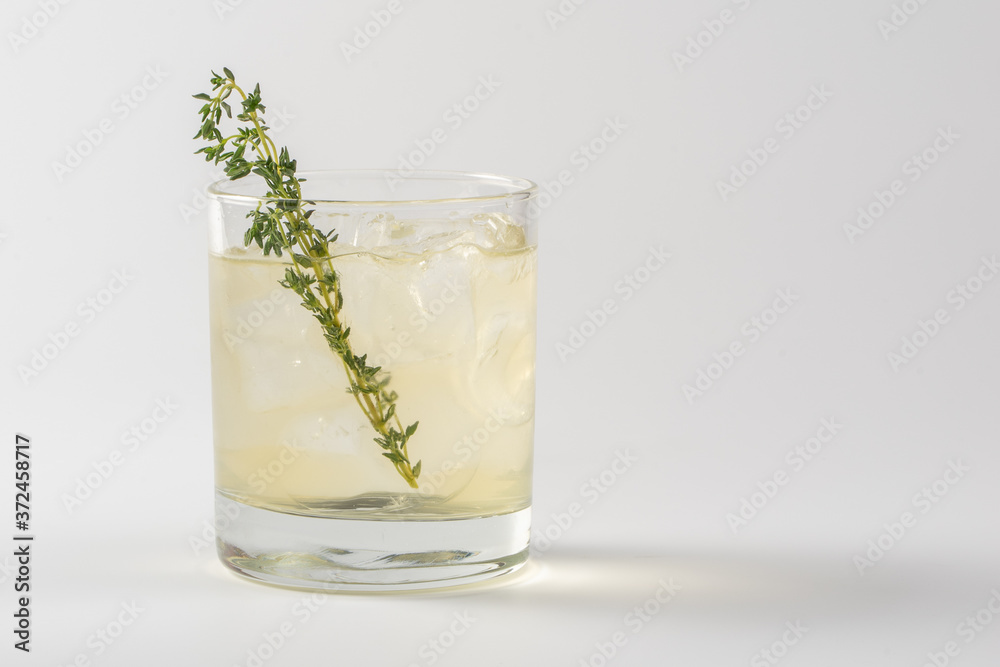 Alcoholic cocktail decorated with thyme in a glass glass on a white background Alcoholic cocktail decorated with thyme in a glass glass on a white background