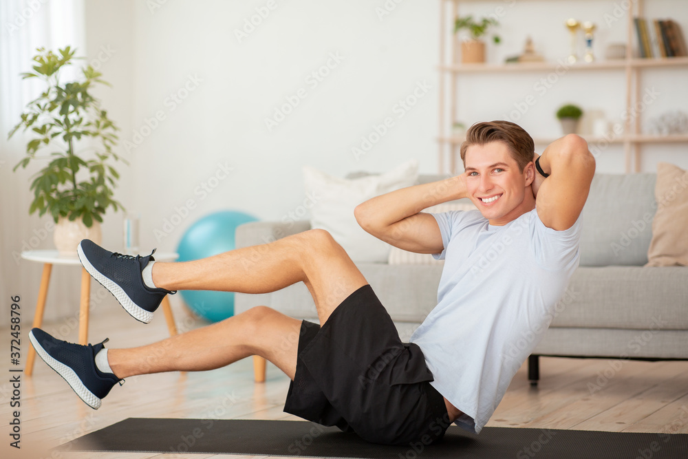 Simple workout at home to keep fit. Handsome guydoing exercises for press Simple workout at home to keep fit. Handsome guydoing exercises for press