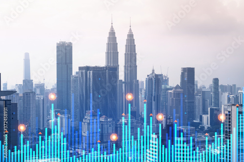 Financial stock chart hologram over panorama city view of Kuala Lumpur. KL is the business center in Malaysia, Asia. The concept of international transactions. Double exposure.