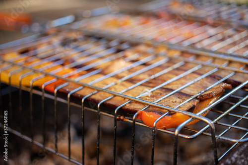 Cooking vegetables on the grill. Charcoal eggplants and bell peppers. Healthy eating. Close-up