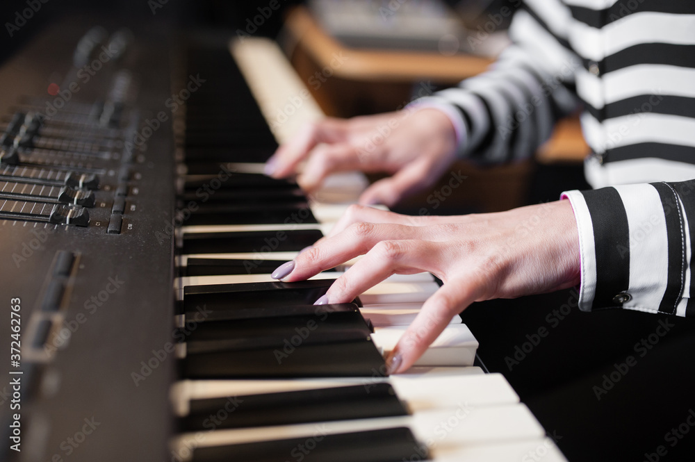 Fototapeta premium WOMAN'S HANDS PLAYING THE PIANO