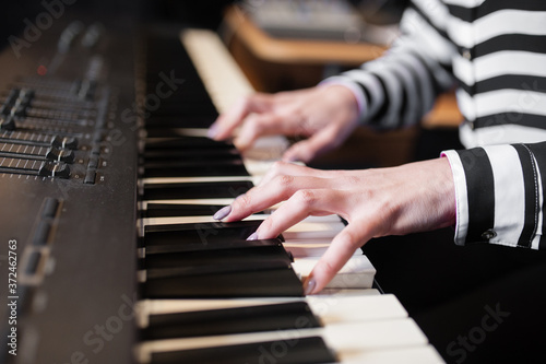 WOMAN'S HANDS PLAYING THE PIANO