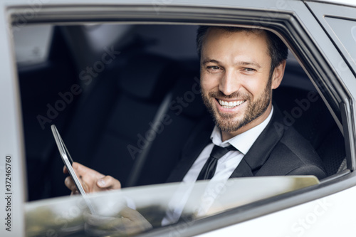 Smiling handsome businessman in suit sitting in car © Prostock-studio