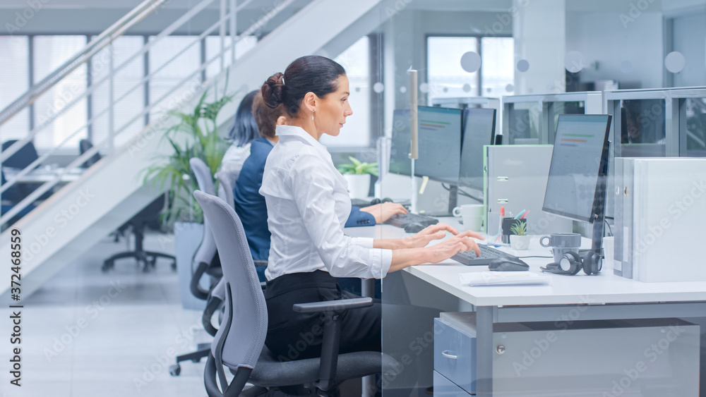 Beautiful Female Manager Works on a Desktop Computer. Diverse and Motivated Business People Work on Computers in Bright Modern Open Office.