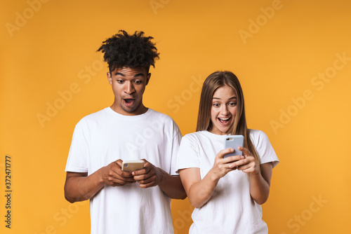 Happy young loving couple isolated over yellow