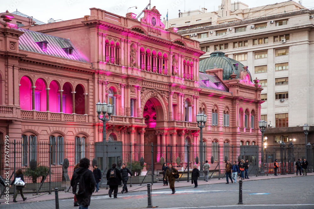 Buenos Aires, Argentina: illuminated presidential palace Casa Rosada at sunset during rusk hour; nonbody appears to be surprised by the remarkable pink lights 
