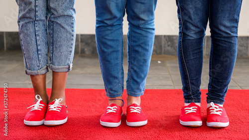 Red shoes on a red carpet people wearing jeans 