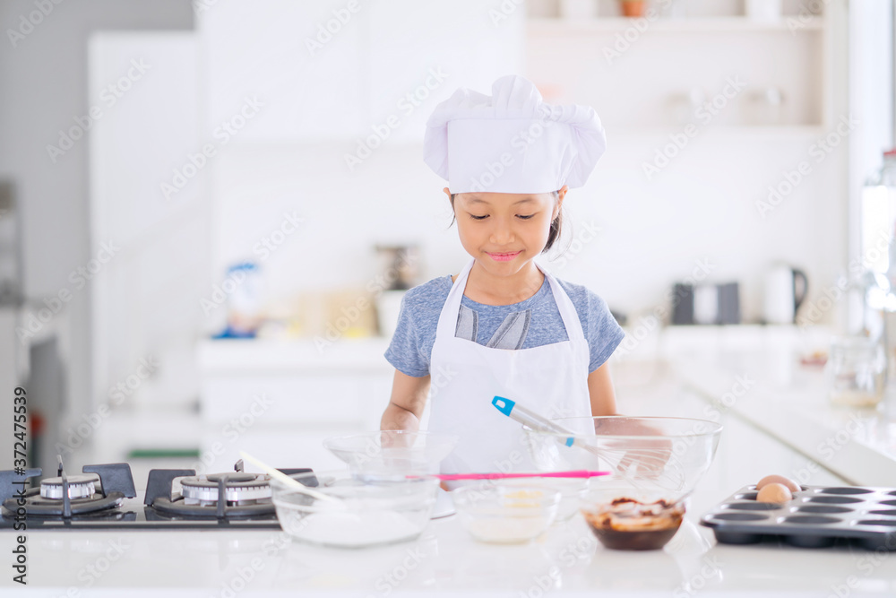 Happy little girl preparing dough in kitchen Happy little girl preparing dough in kitchen