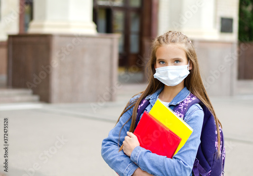 Little girl child with face mask and backpack. Education concept. Back to school after covid-19. © svetamart