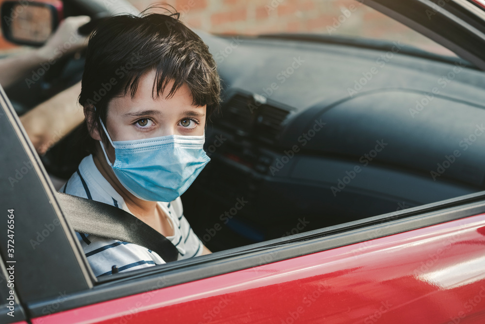 kid wearing medical mask riding in a car kid wearing medical mask riding in a car