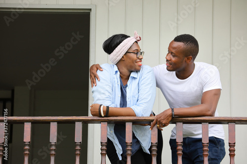 Young newly wed African American couple leaning on the balcony at home with copy space