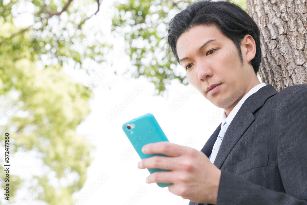 スマホを見るビジネスマン スマホを見るビジネスマン