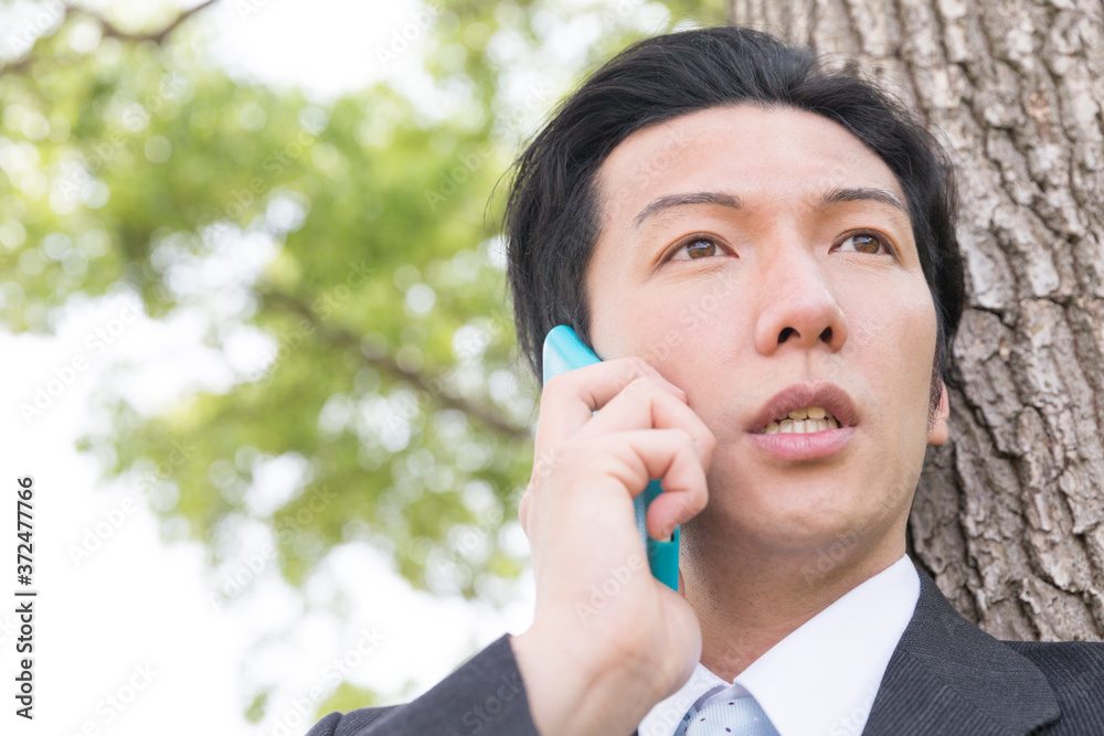 スマホで電話するビジネスマン