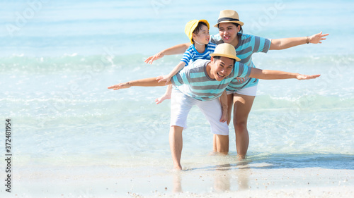 Asian happy family have fun fly on the beach for leisure and destination. Family people tourism travel enjoy in summer and holiday. 