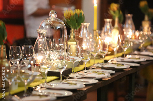 Event table setting with lots of glass and candle lighting.
