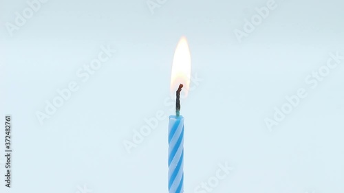 blue birthday candles light on isolated white