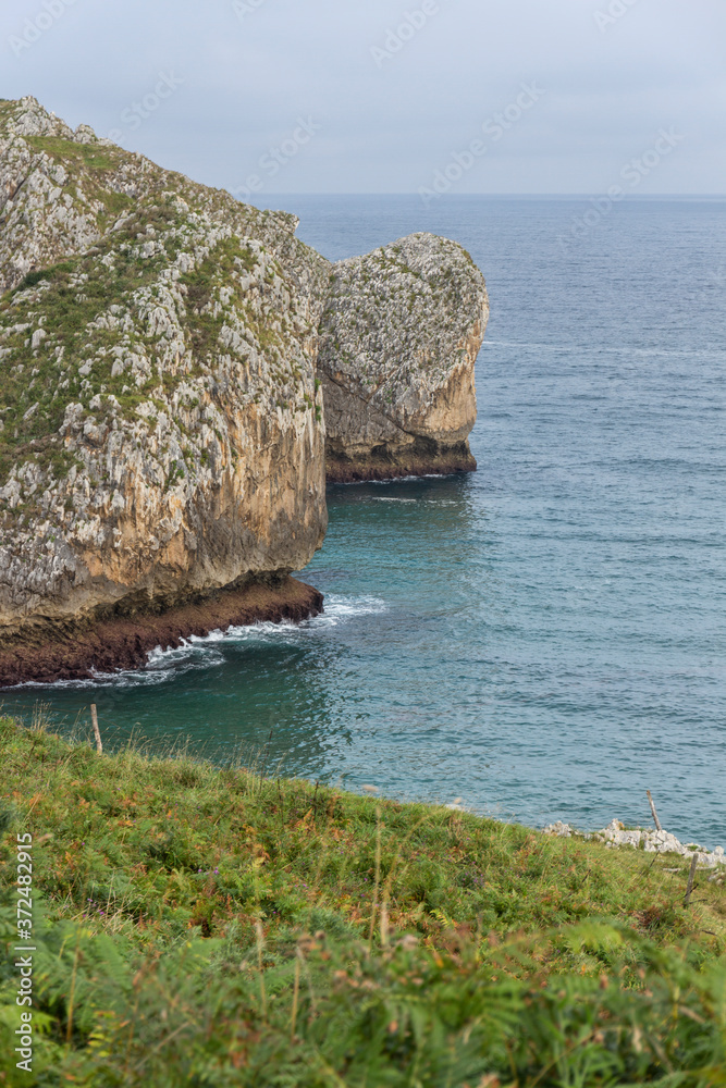 Cliffs of the Cantabria coast next to the beach on a cloudy day