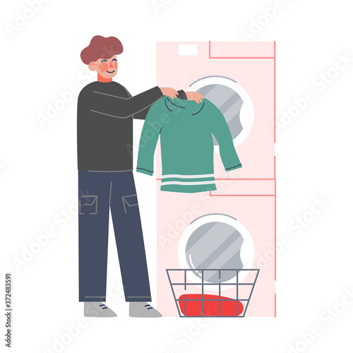 Young Man Doing Laundry at Home or Public Laundrette, Guy Washing and Drying Clothes in Washer Flat Style Vector Illustration