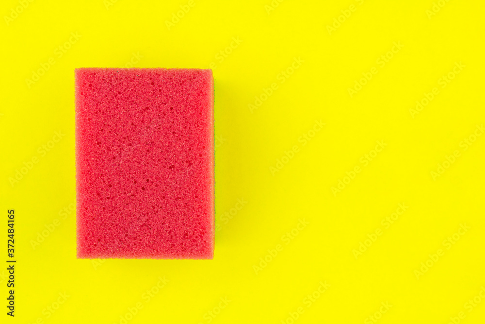 Red soft sponge on yellow background. Copy space for text. Red soft sponge on yellow background. Copy space for text.