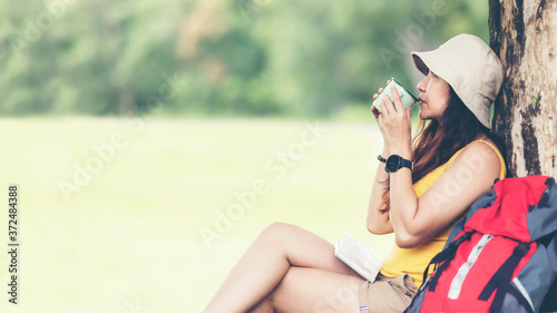 Hiker Asia woman sitting and drinking coffee for relax and rest on mountain. Female adventure backpack and trips camping on hike in outdoor nature. 
