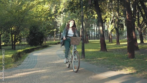 Wallpaper Mural Happy woman riding bike in the park on sunny morning Torontodigital.ca