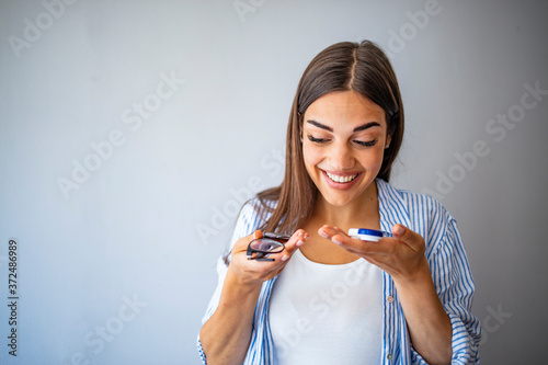 Woman choosing between eyeglasses and contact lenses. Lifestyle. Myopia and eyesight problem concept. Girl holding glasses in one hand and contact lens other hand